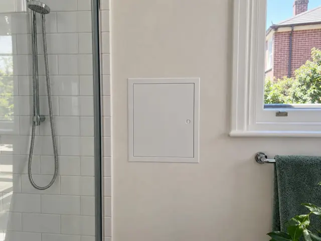 Neat white access panel on a bathroom wall beside a shower and window in Rozelle